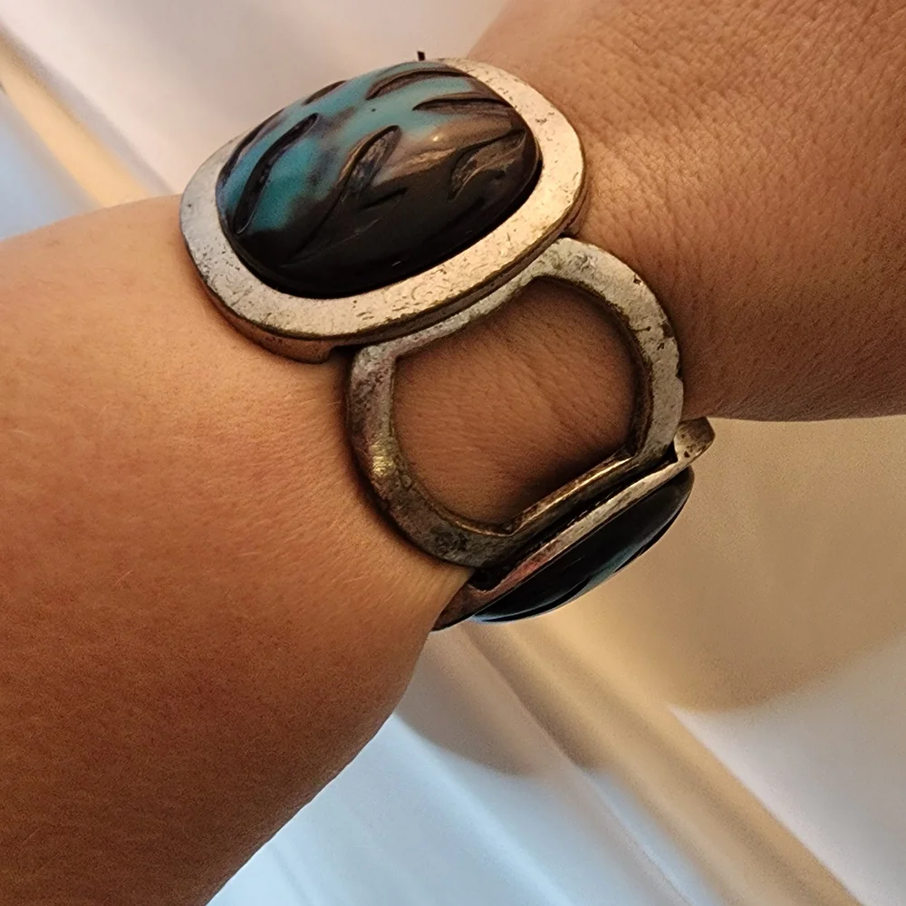 Cuff bracelet with a large, square, blue and black stone set in a Silver Tone